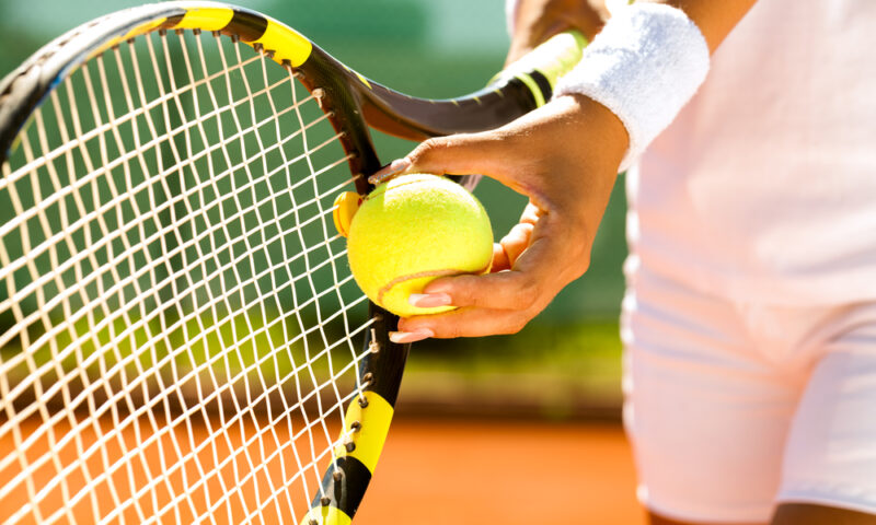Player’s hand with tennis ball preparing to serve